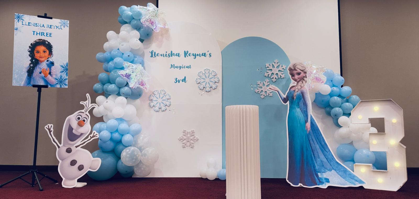 Frozen birthday setup with personalised backdrop, Elsa, Olaf and number light